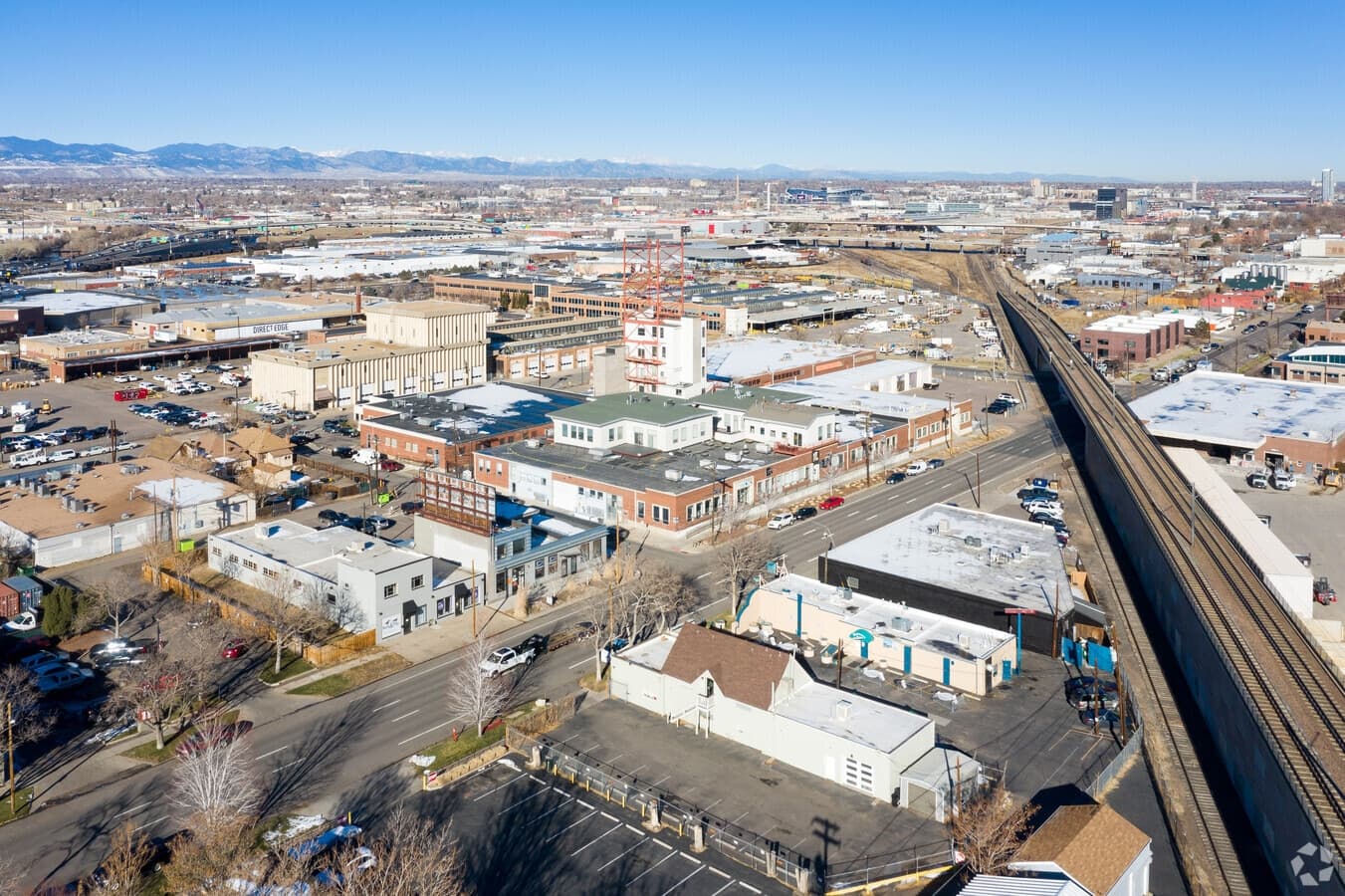 Aerial view of photospace in Denver's Sun Valley — the studio, the rail line, and the Rockies on the horizon